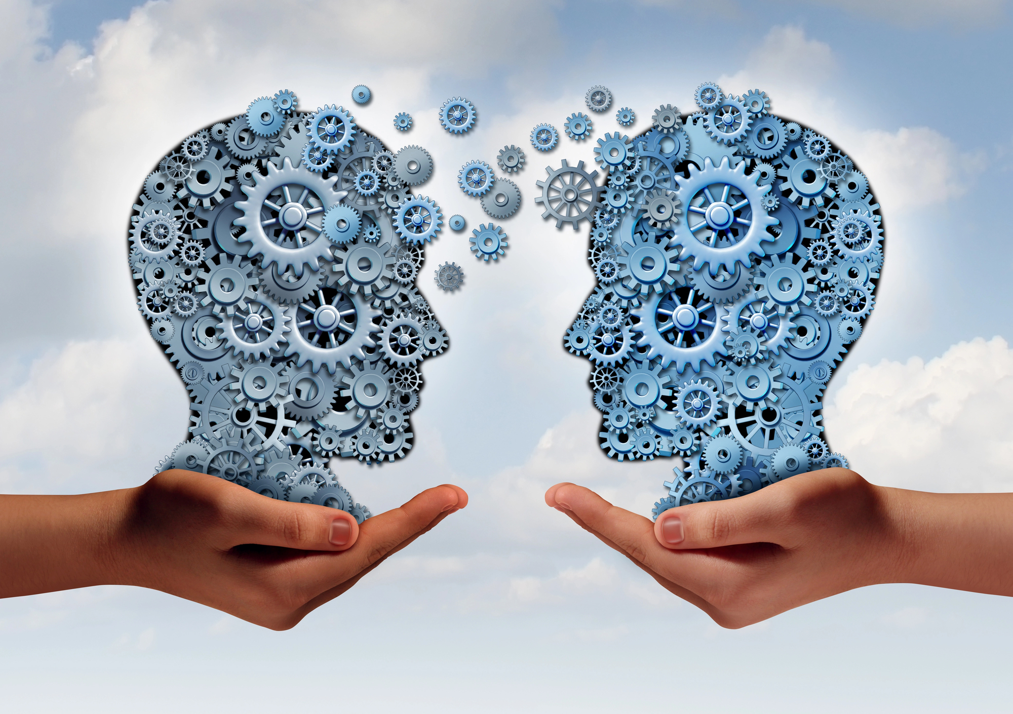 Illustration of two human profiles facing each other, composed of interlocking blue gears and cogs. Each head is supported by a large hand, set against a cloudy sky background, symbolizing ideas and communication.