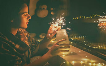 young woman lighting sparklers in a jar - illustrating appreciating what you have