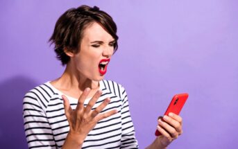 A woman with short brown hair is wearing a striped shirt and red lipstick. She looks frustrated, yelling while holding a red smartphone in one hand. Her other hand is raised with fingers splayed against a purple background.