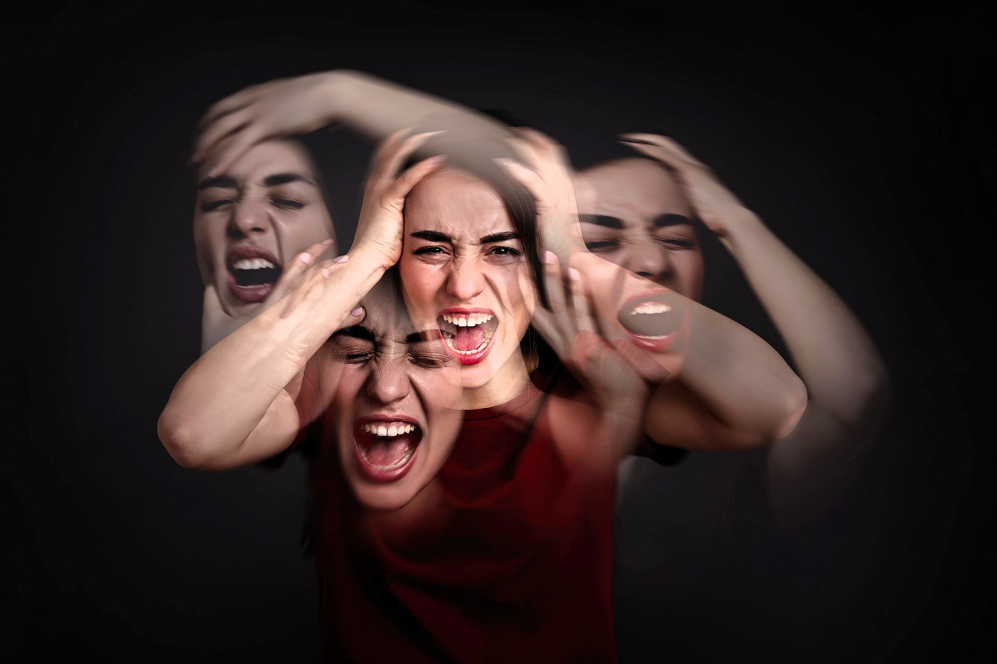 A woman is holding her head with a pained expression. The image is blurred and layered to convey a sense of motion and distress, set against a dark background.