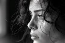 black and white closeup photo of a young woman with a tear near her eye