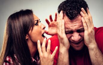 A woman with long brown hair is yelling; her hand is raised in frustration. A man with short curly hair, wearing a red shirt, is holding his hands to his head, showing distress or frustration. Both express intense emotions.