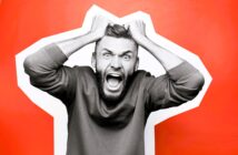 A man with a beard is pulling his hair and yelling, appearing frustrated. He's against a bright orange background with a white abstract shape. He's wearing a casual sweatshirt.