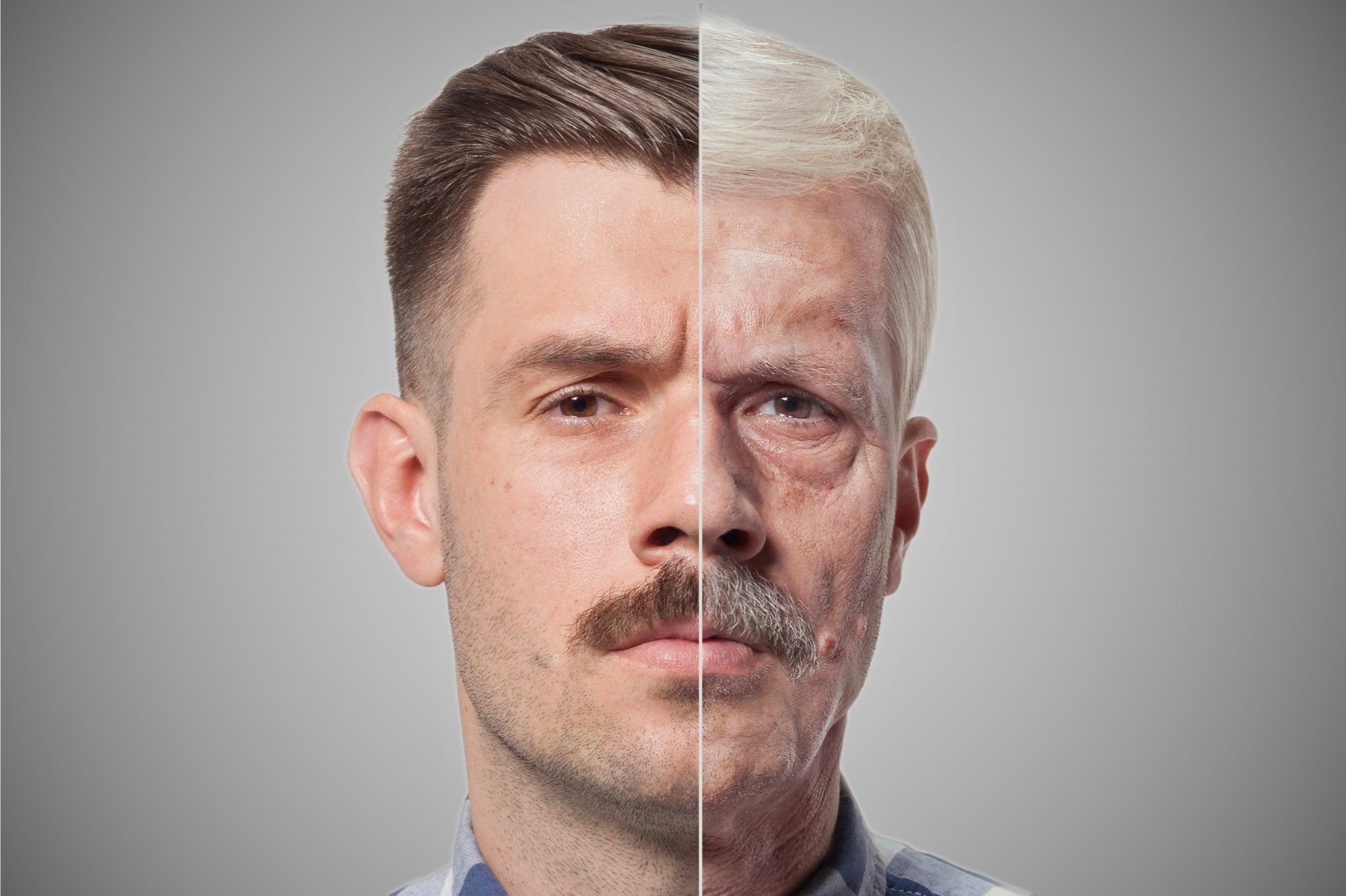 A split image of a man's face, where the left side shows him younger with brown hair and a mustache, while the right side shows him older with gray hair and a mustache. The background is a neutral gray.