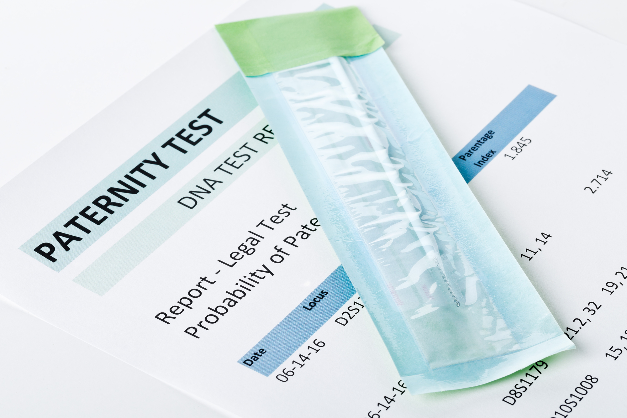 A paternity test report displaying probability of paternity with numbers, alongside a sealed DNA test swab. The report appears to contain a positive result, with percentages and case details partially visible.